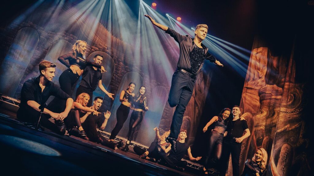 Irske dansere i glitrende tøj på en scene med spotlight